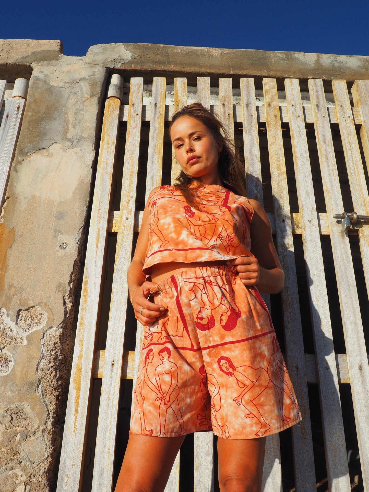 Up-cycled vintage cotton shorts with elastic waist and printed karma sutra design in burnt orange.