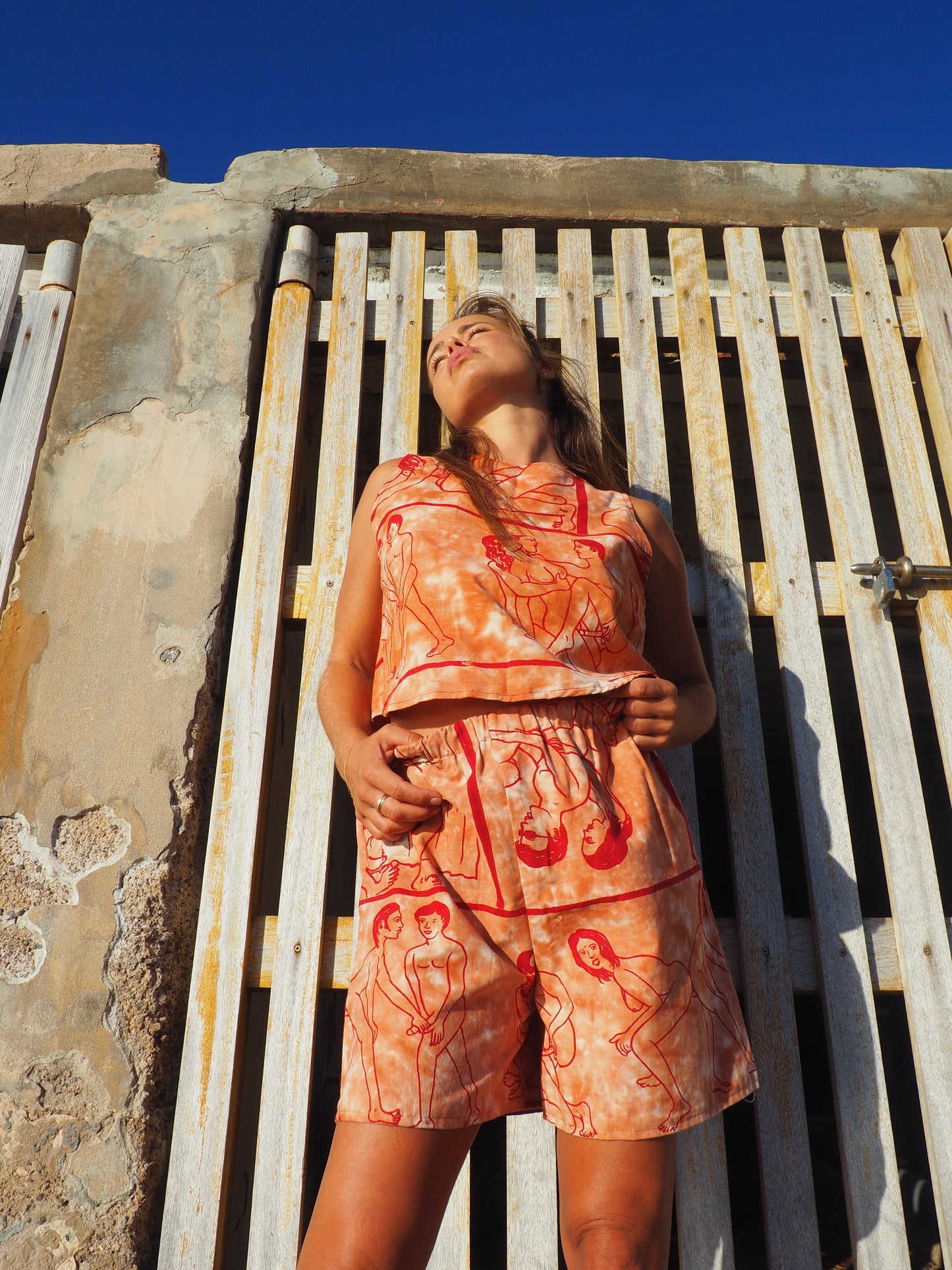 Up-cycled vintage cotton shorts with elastic waist and printed karma sutra design in burnt orange.