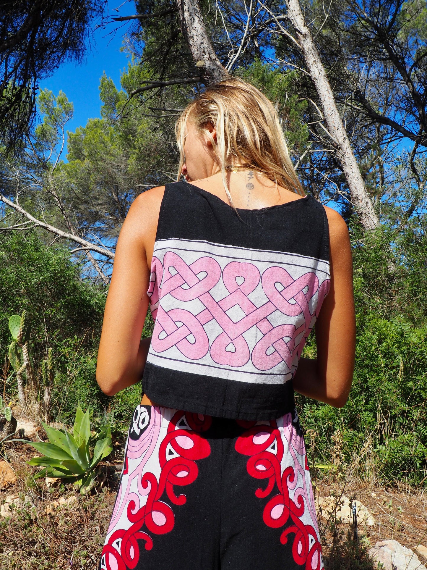 Up-cycled cotton short sleeve crop top in pink and black with vibrant print design and circular motifs by Vagabond Ibiza made