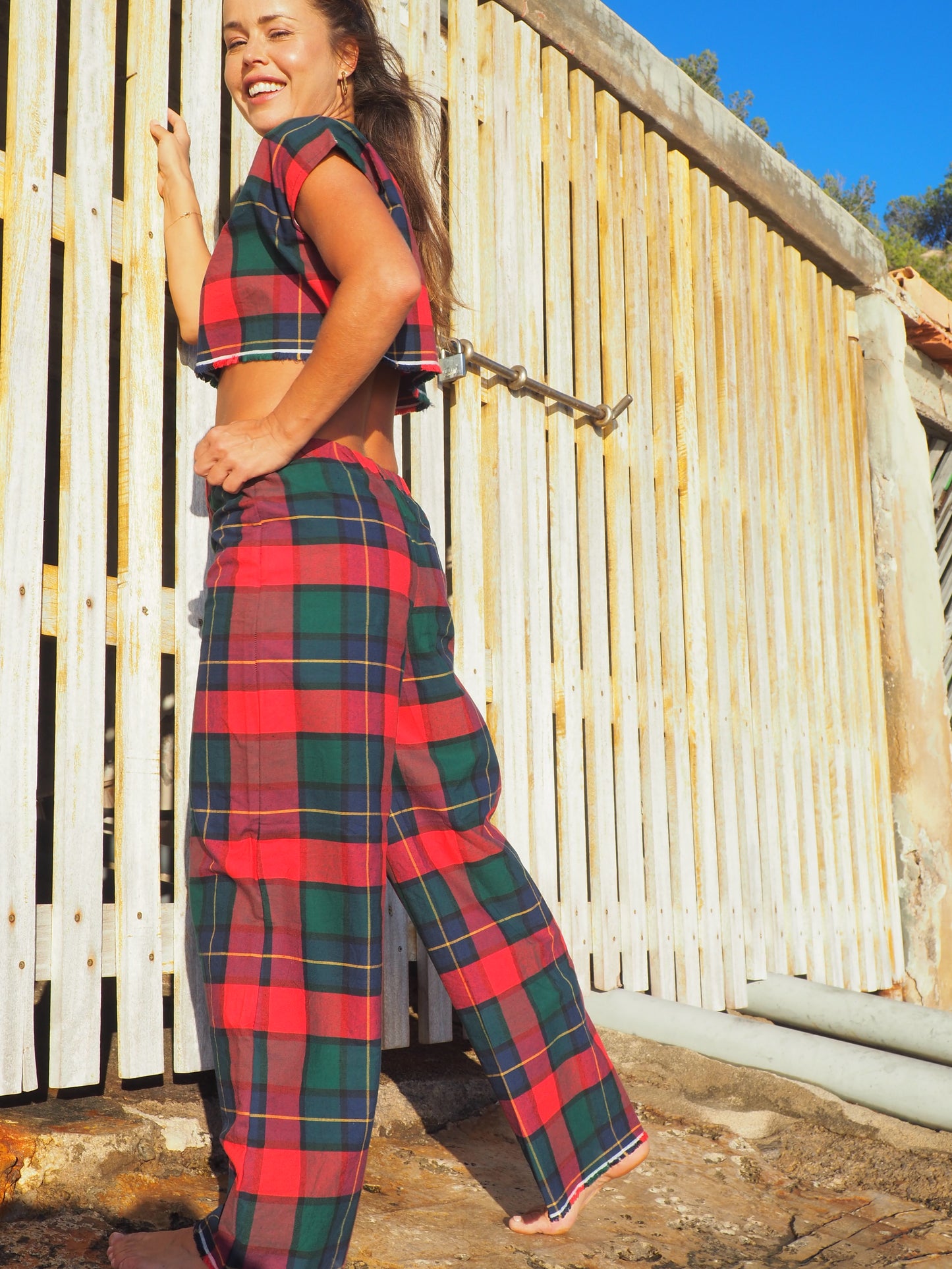 A stunning two-piece upcycled set featuring a vibrant red and blue checked design wide leg pants with elastic waste and crop top.
